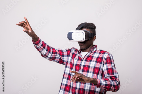 young happy and excited afro american man pointed button wearing virtual reality vr 360 vision goggles enjoying video game isolated on whitebackground in innovation and gaming technology concept
