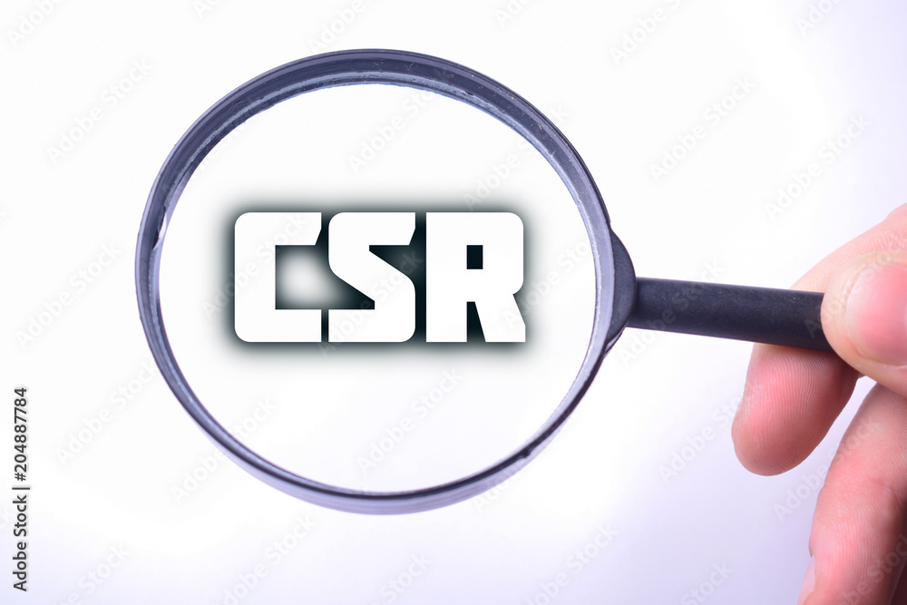 Businessman looking at a magnifying glass word:CSR Businessman looking at a magnifying glass word:CSR