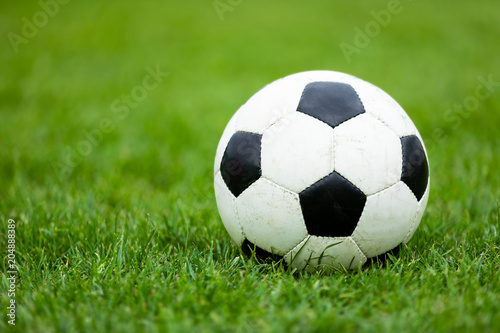 Classic Soccer Football Ball on Soccer Pitch. Green Grass Soccer Field. Soccer Turf in the Background