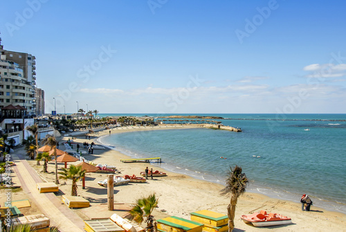 Alexandria, Egypt, 21 February 2018: View of Alexandria harbor, beach, palms and buildings