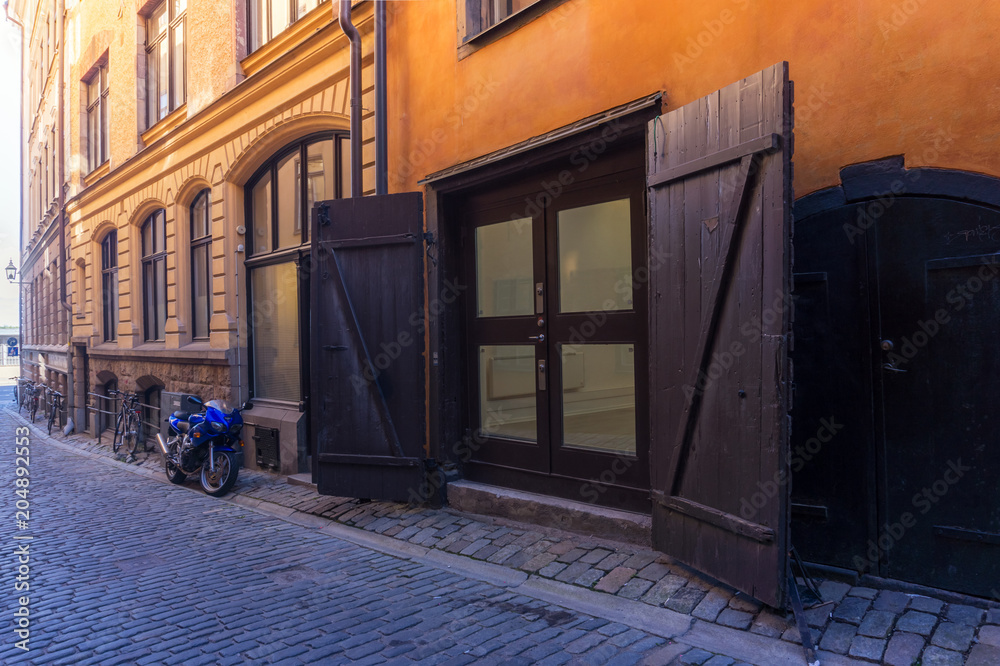 Motorcycle and wooden gate on the Old Town street in Stockholm, Motorcycle and wooden gate on the Old Town street in Stockholm,