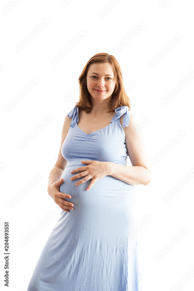 Pregnant woman wearing a long blue dress over white background in studio photo Pregnant woman wearing a long blue dress over white background in studio photo