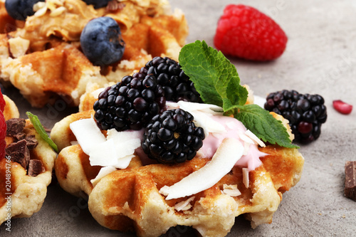Belgian waffles with pomegranate and raspberries, homemade healthy breakfast with mint