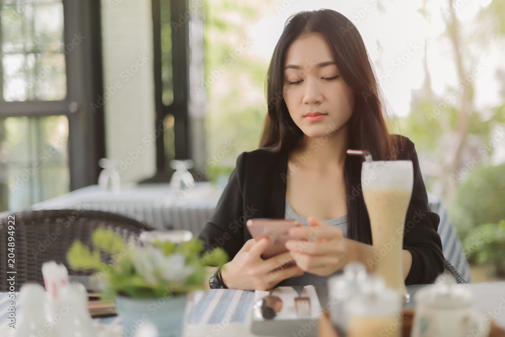 Portrait of asian woman use smartphone in coffee shop. Business woman wait customer in resturant. Portrait of asian woman use smartphone in coffee shop. Business woman wait customer in resturant.