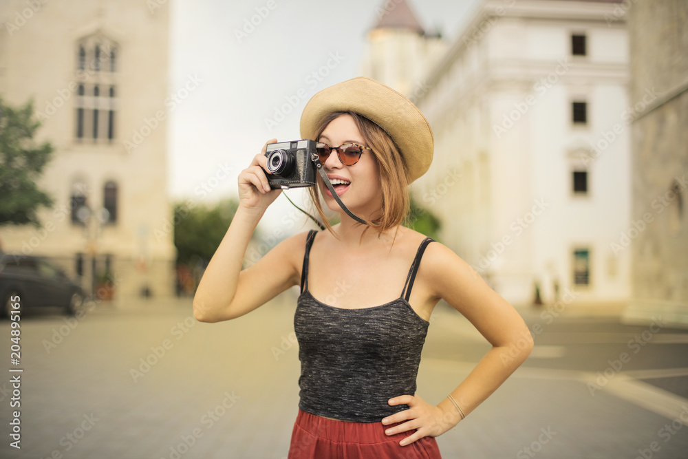 Cheerful girl using a vintage camera