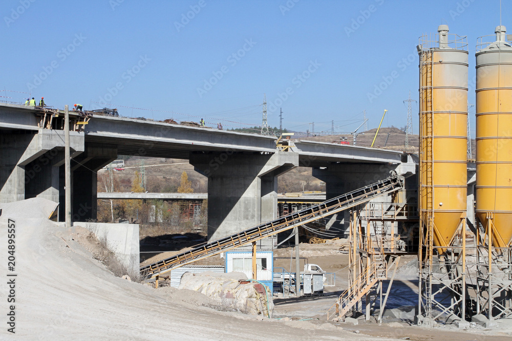 New highway under construction. A new bridge freeway made of concrete and metal to pass traffic from big city. An unfinished interstate bridge. Road under construction. Overpass road  on a sunlight. 