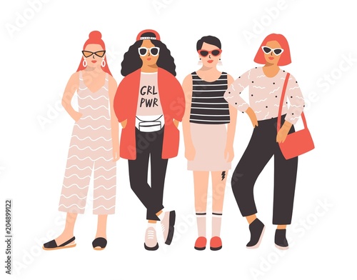 Four young women or girls dressed in trendy clothes standing together. Group of friends or feminist activists. Female cartoon characters isolated on white background. Flat colored vector illustration.