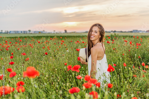Happy woman in the field of red poppies