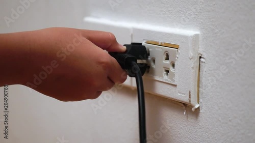 Slow motion little hand and electric plug, safety concept