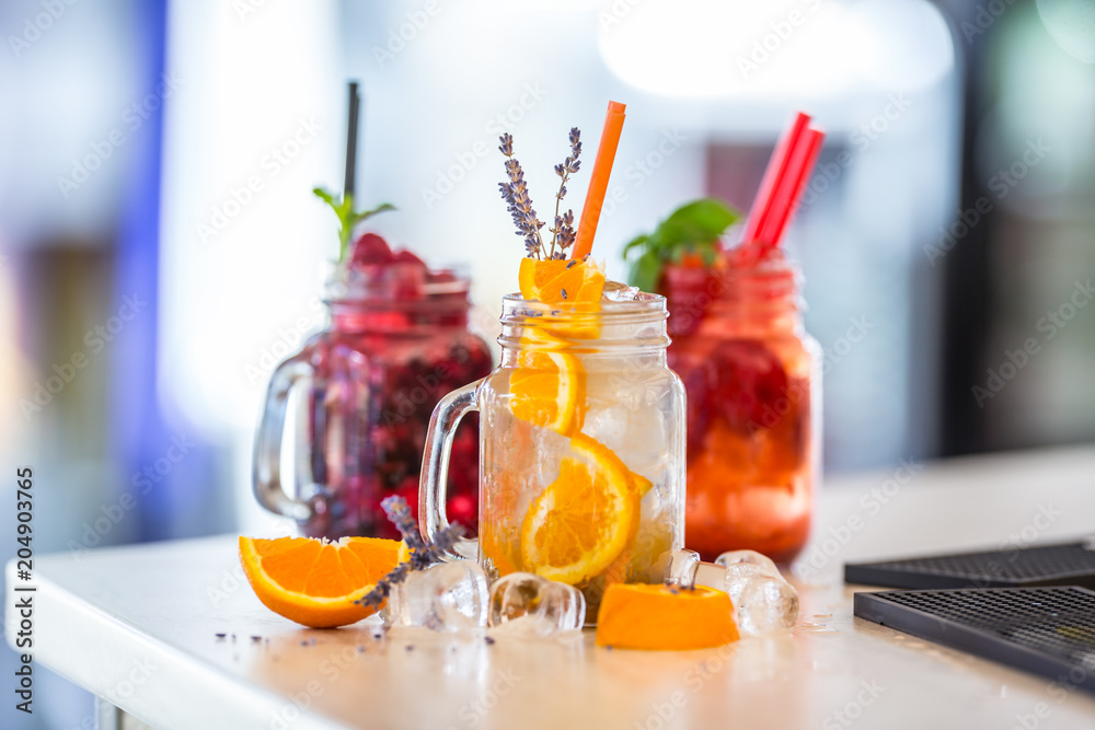 Various lemonades in mason jars with orange lime lemon otange strawberries and fresh fruit fruits Various lemonades in mason jars with orange lime lemon otange strawberries and fresh fruit fruits