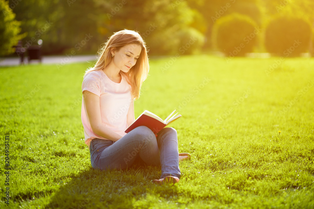 Girl reading book sitting on grass Girl reading book sitting on grass