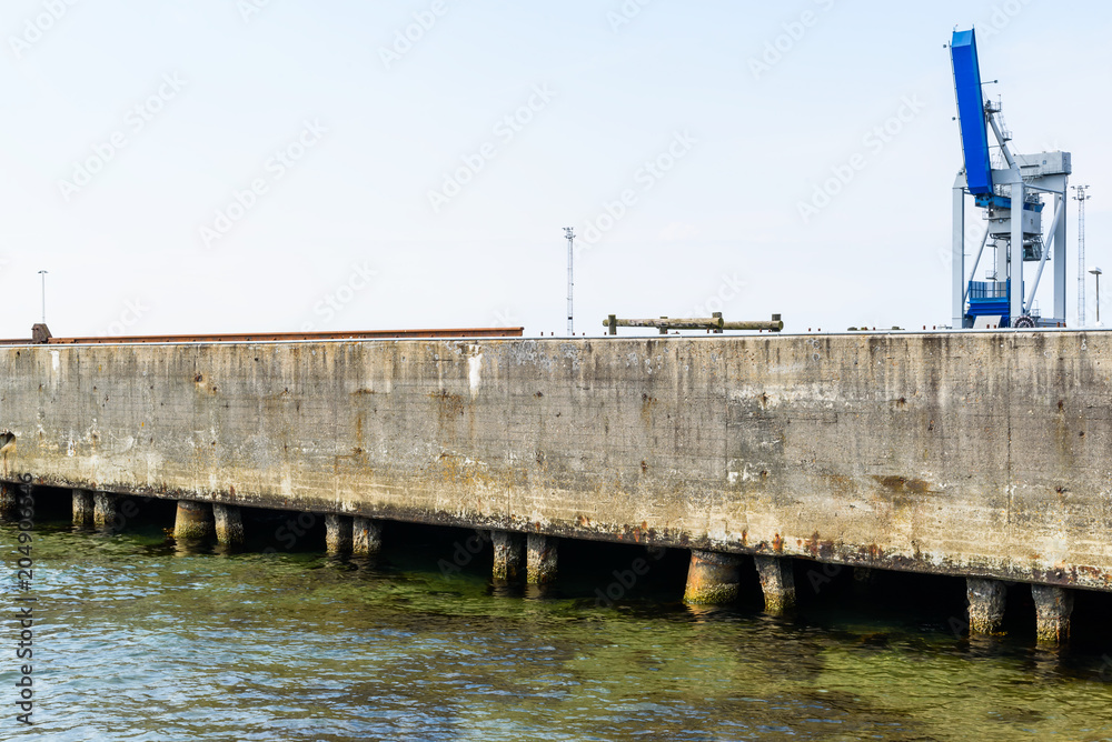 Obraz premium Harbor crane on an industrial concrete pier. Logo removed.