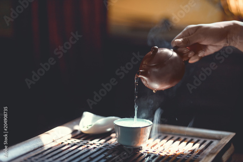 Tea master pouring tea in sunlight