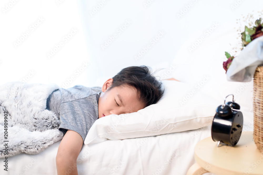 Sleeping boy on a white bed Sleeping boy on a white bed