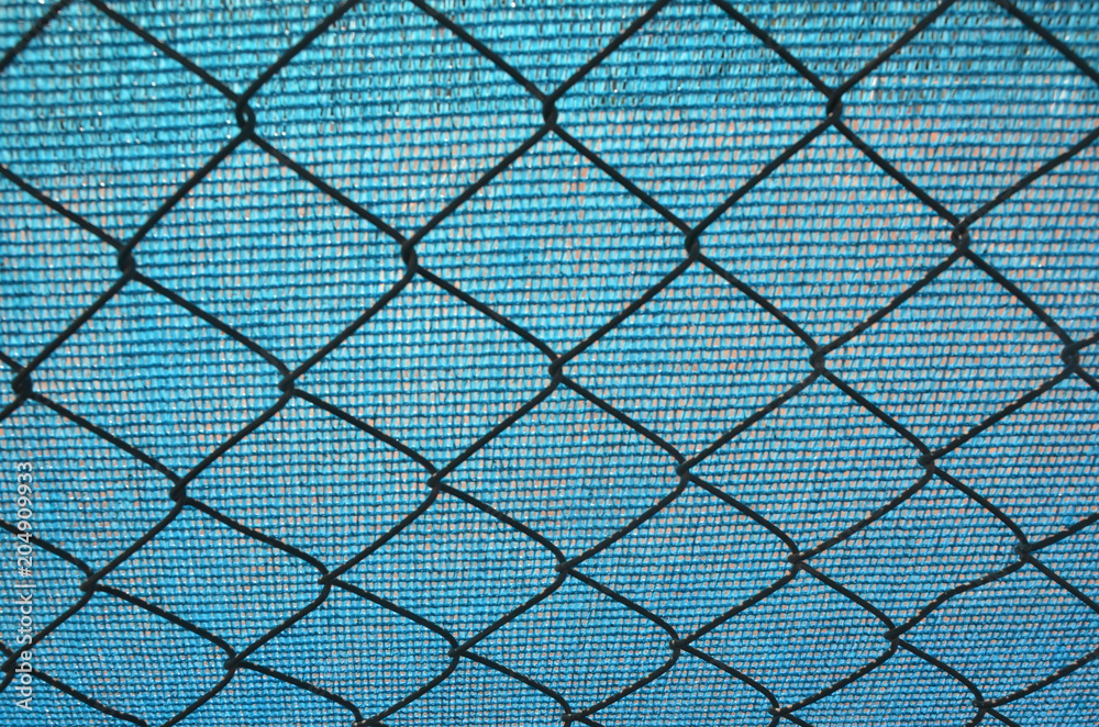 Naklejka premium Chain link fence and blue tarpaulin