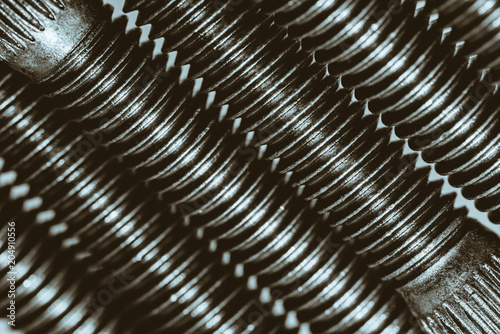 Monochrome background from automotive bolts close up.