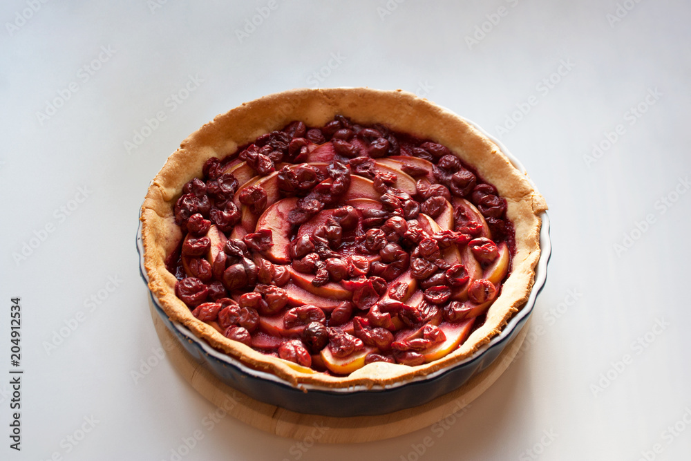 Freshly baked pie filled with sliced apples and cherries isolated on white background Freshly baked pie filled with sliced apples and cherries isolated on white background