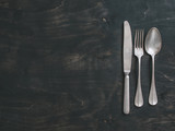 Vintage cutlery on dark background, copy space