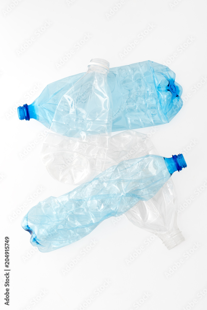 Different types of crushed plastic bottles on white background. Recyclable waste. Recycling, reuse, garbage disposal, resources, environment and ecology concept.