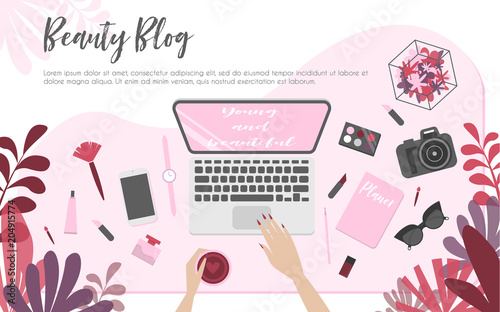 Workplace of beauty blogger, view from above, desktop, laptop, camera, cosmetics and flowers