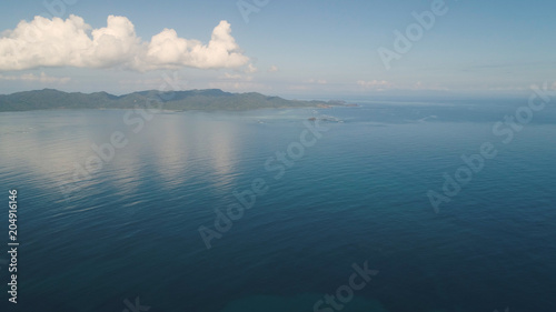 Aerial view of islands and coral reefs with turquoise water in blue lagoon  Philippines  Santa Ana. Seascape ocean coastline  mountains and blue sky with clouds. Tropical landscape in Asia.