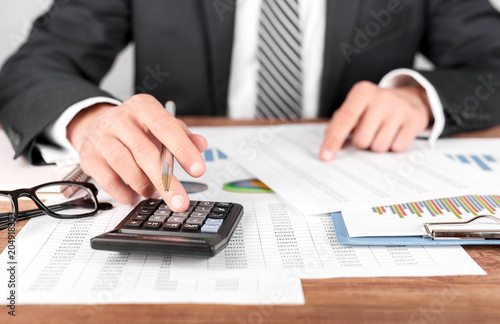 Businessman working with using a calculator to calculate the numbers. Finance accounting concept