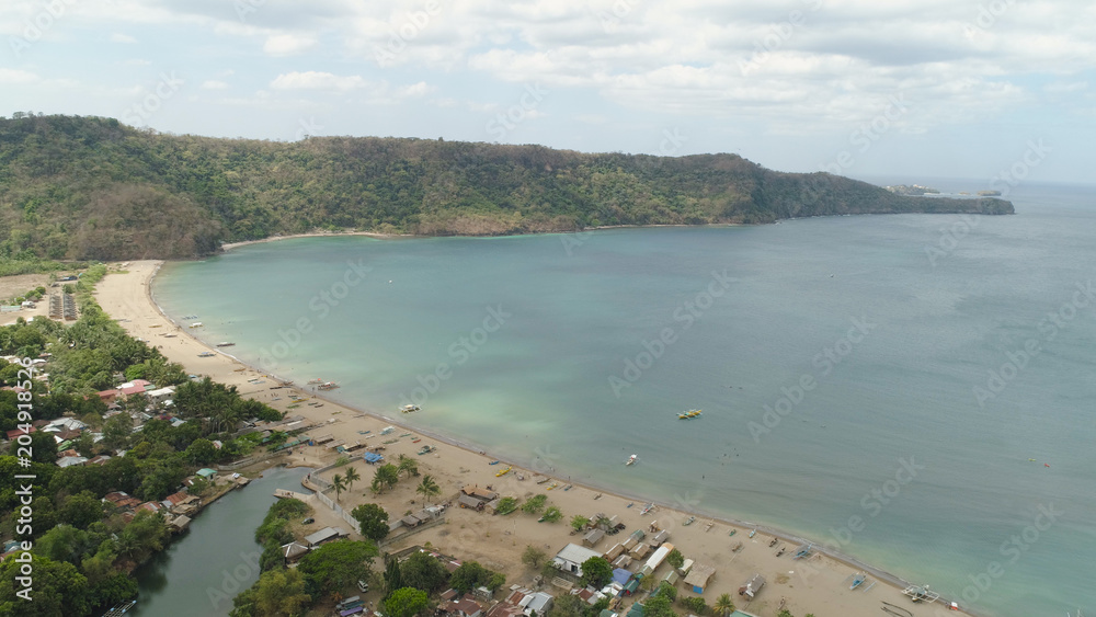 Aerial view of coast with beach in blue lagoon. Philippines, Luzon. Coast ocean with tropical beach, turquoise water. Tropical landscape in Asia.