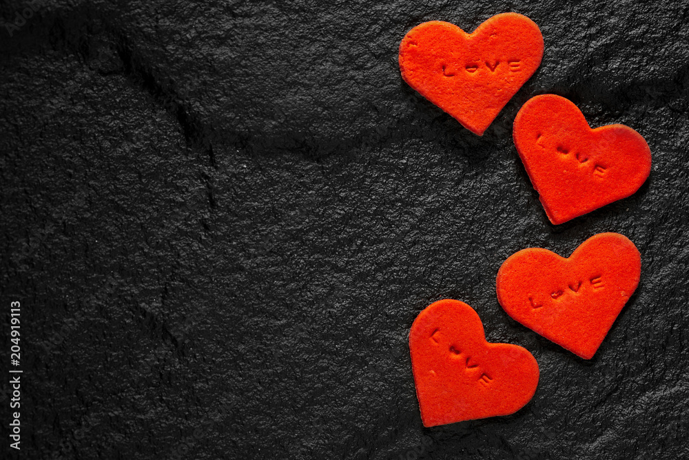Red heart written love words placed on black stone floor Red heart written love words placed on black stone floor