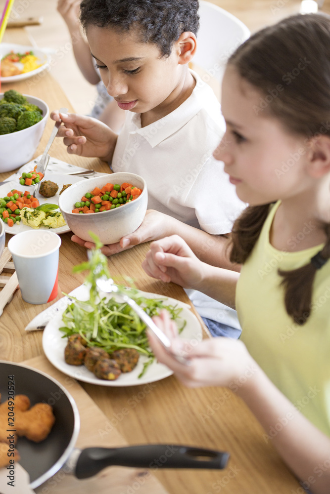 Plakat High angle of children eating vegetables for dinner at school