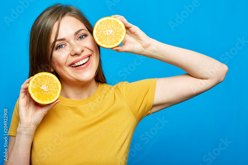 Close up face portrait of smiling woman holding two orange slice