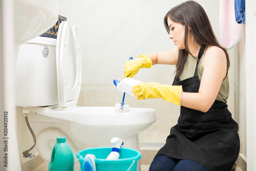 Young maid in yellow glove cleaning toilet bowl using brush and detergent  Stock Photo | Adobe Stock