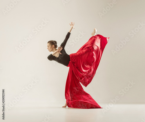 Modern ballet dancer dancing in full body on white studio background.