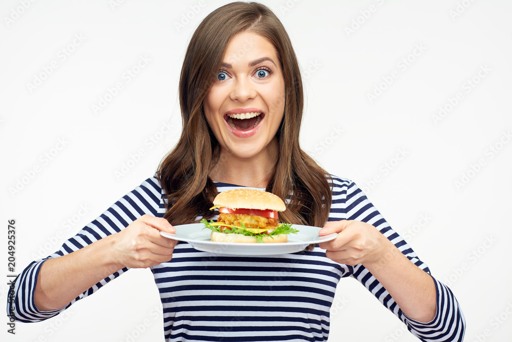 Happy emotional woman holding burger on white plate. Happy emotional woman holding burger on white plate.