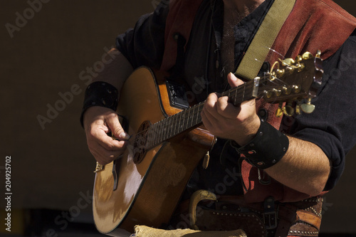 street musician playing the mandolin through the streets of a city
 photo