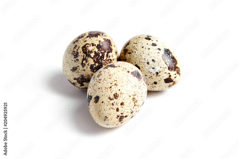 Three Quail spotted eggs, isolated on a white background