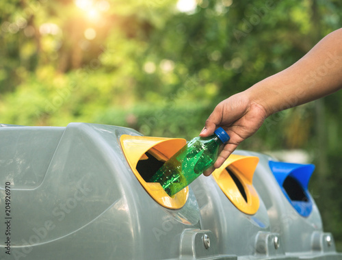 Close up of hands putting water bottles in recycling bin. Recycled waste or garbage can be sold and reused. Global warming concept