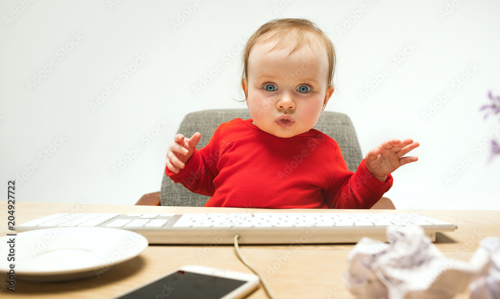 Happy child baby girl toddler sitting with keyboard of computer isolated on a white background Happy child baby girl toddler sitting with keyboard of computer isolated on a white background