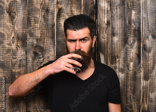 Man with beard and mustache holds alcoholic beverage photo