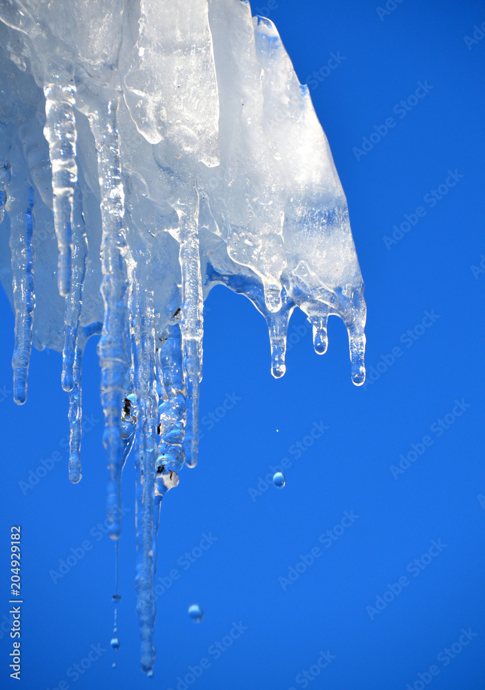 Drops falling from icicle in crisp winter air Drops falling from icicle in crisp winter air