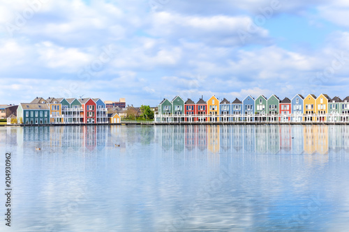 Vivid dutch wooden houses village on canal on sunny day