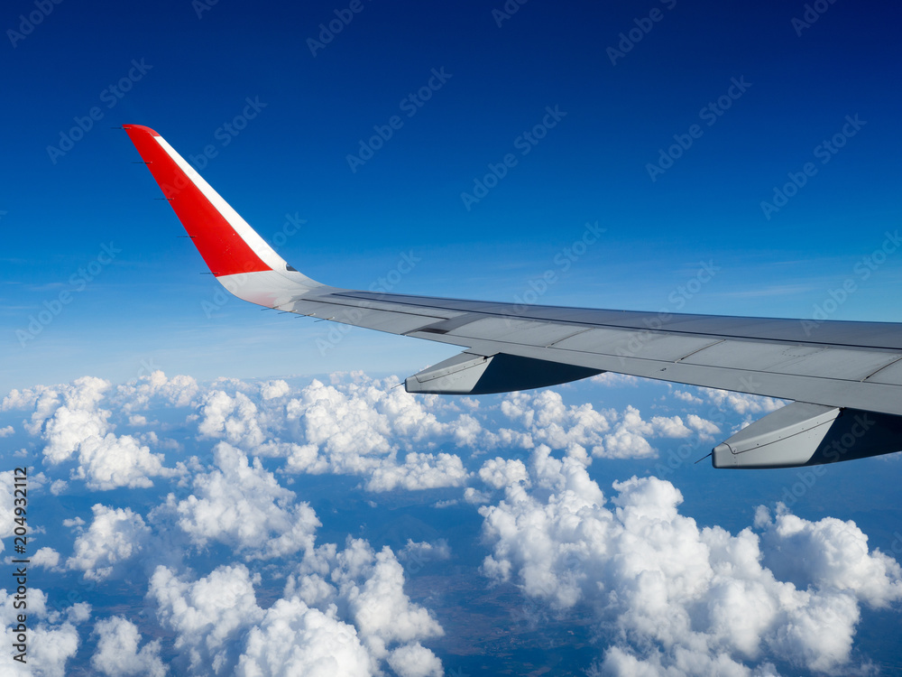 View from airplane windows from passenger, beautiful cloud group and blue sky. Wing aircraft in altitude during flight.Concept of travel and business trip. Traveling concept. View from airplane windows from passenger, beautiful cloud group and blue sky. Wing aircraft in altitude during flight.Concept of travel and business trip. Traveling concept.
