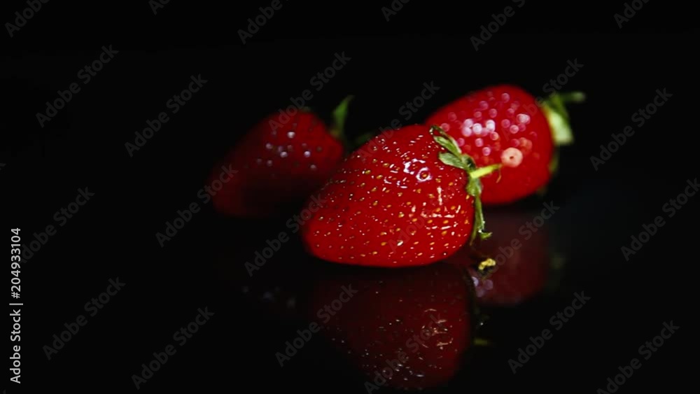 Strawberries lie on a dark table Strawberries lie on a dark table