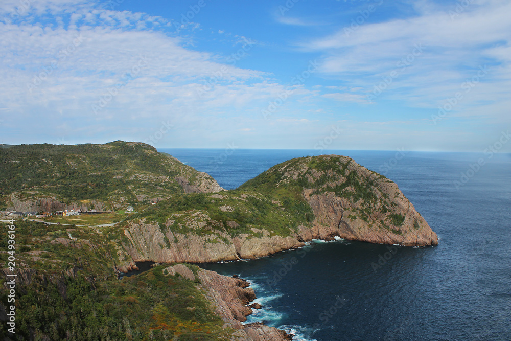 Steep, rocky cliffs along the coastline, St. John's, Newfoundland Labrador, Canada. Panoramic view of the ocean and hilly coastline.