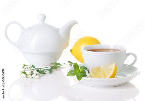 White teacup, teapot with herbal tea