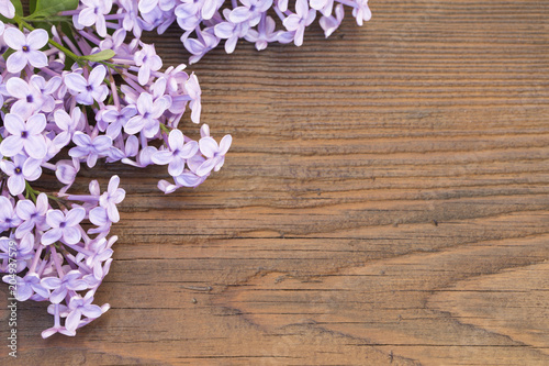 Fresh flowers frame of purple Lilac flowers on wooden background