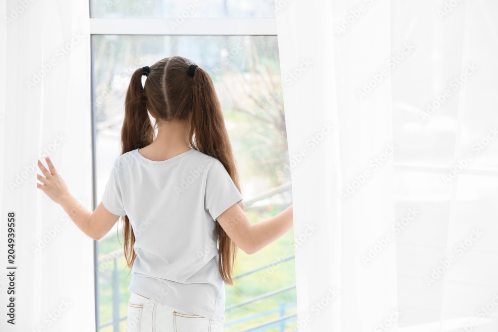 Little girl standing near window. Autism concept Little girl standing near window. Autism concept