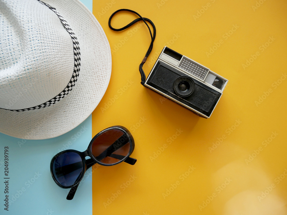 Flat lay of accessories items for travel with camera, hat and sunglasses on colorful background. Holiday concept. - obrazy, fototapety, plakaty 