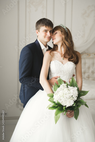 Perfect wedding couple holding luxury bouquet of flowers