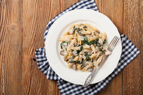Penne pasta with spinach and mushrooms. Sprinkled with cheese.