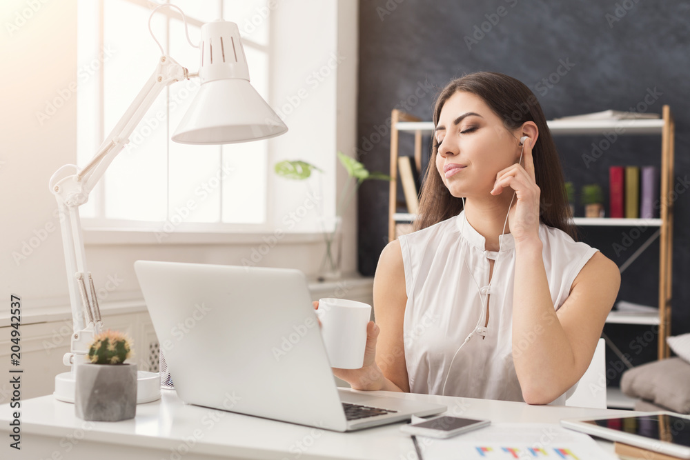 Young woman working on laptop and consulting on phone